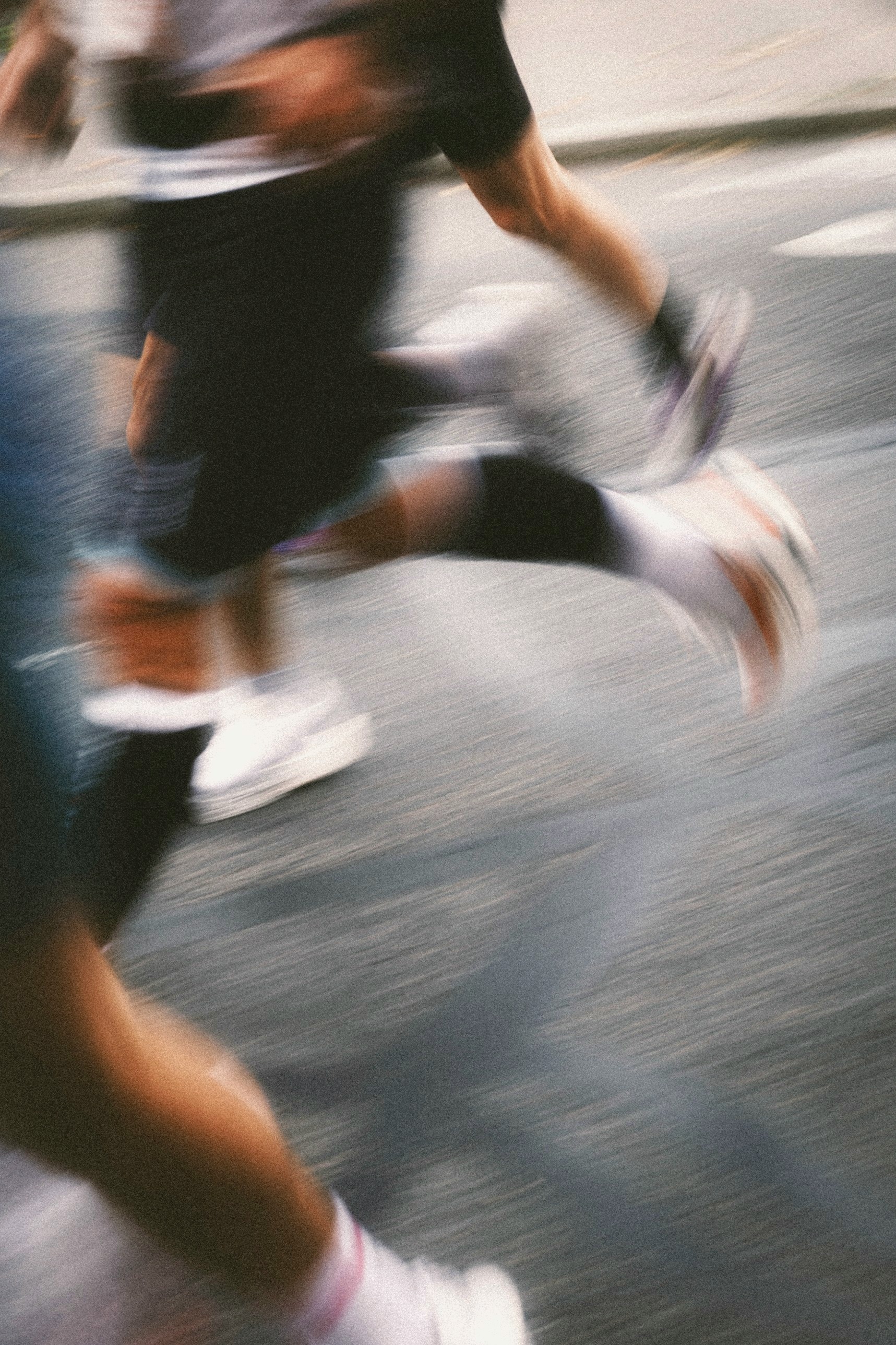 Runners on a street, their legs blurred mid-stride.