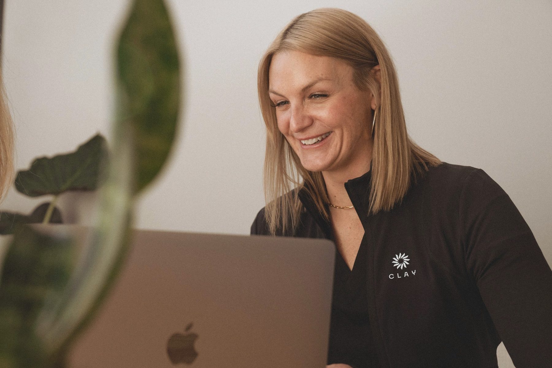 A team member smiling at her laptop.