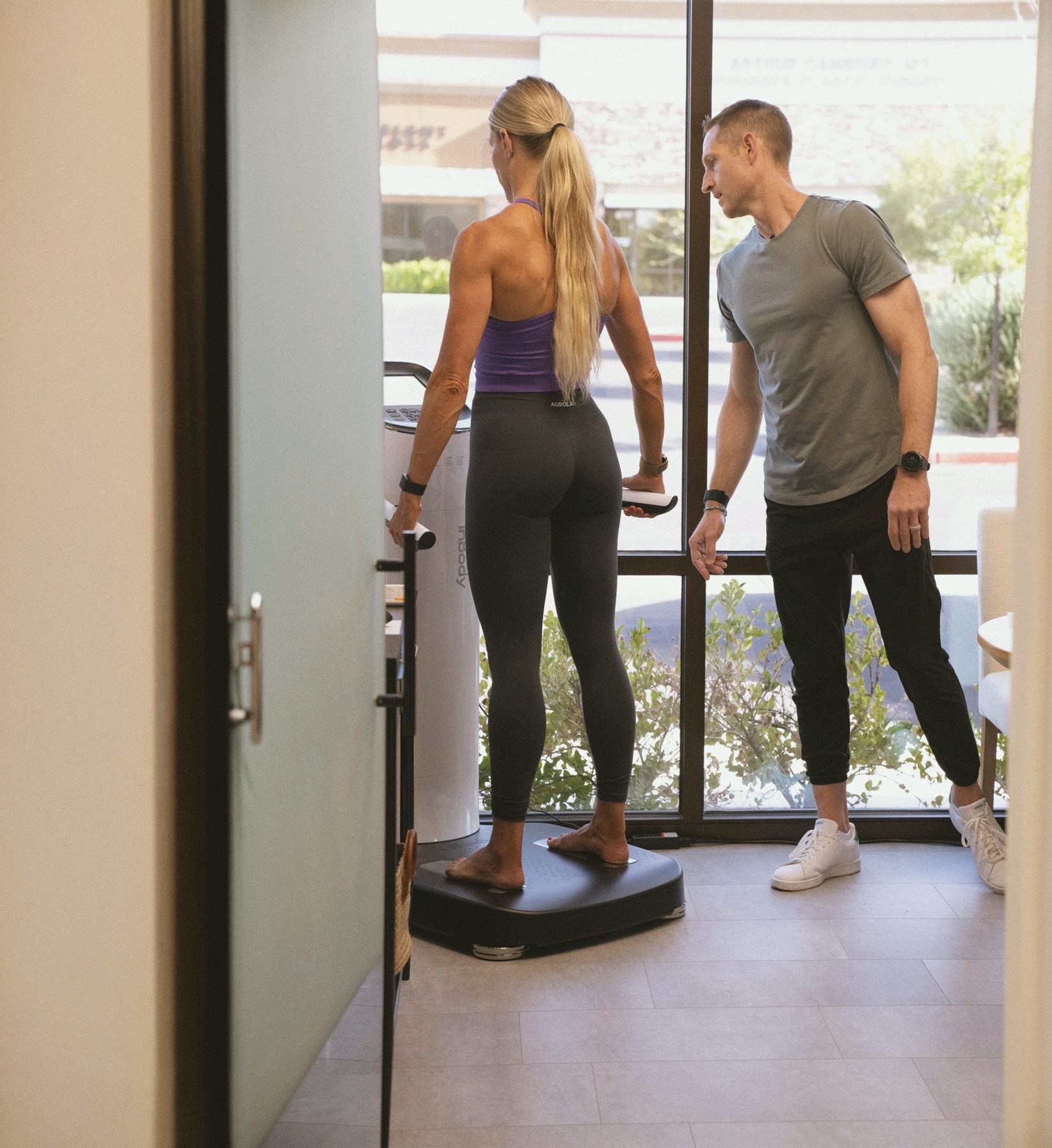 A member on a body composition scale with a team member beside her.