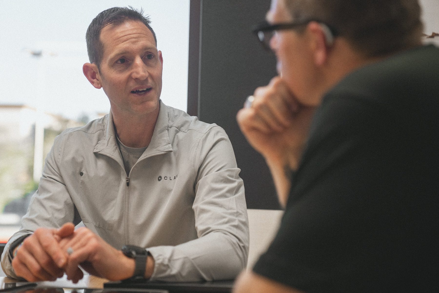 A Health Guide talking with a member across a table.