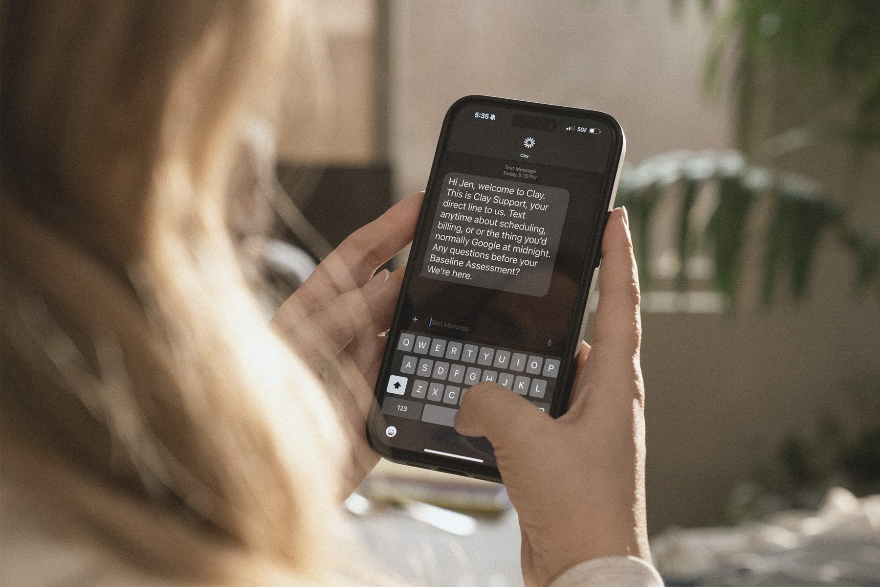 A member reading a text from Clay Support on her phone.
